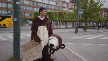 Man i nallebjörnskostym står vid Södervärns bussstation