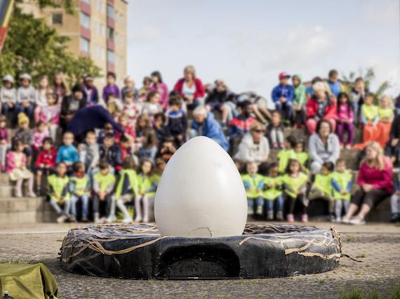 Ägget ligger och väntar på att föreställningen ska börja. Man skymtar publiken i bakgrunden. 