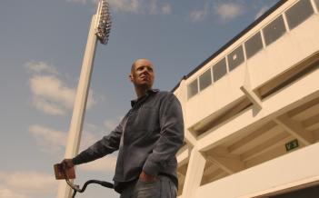 Person står med cykel utanför fotbollsstadion